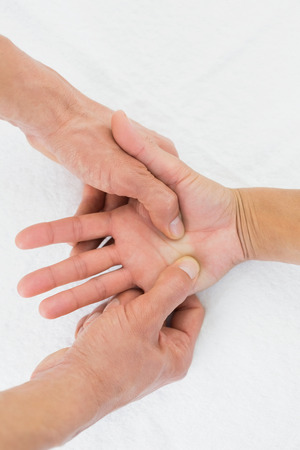 Extreme close-up of a doctor examining a female patient's palm in the medical officeの写真素材