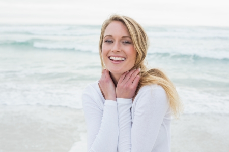 Portrait of a smiling casual young woman standing at the beachの写真素材