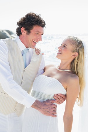 Groom dipping his smiling new wife while dancing at the beachの写真素材