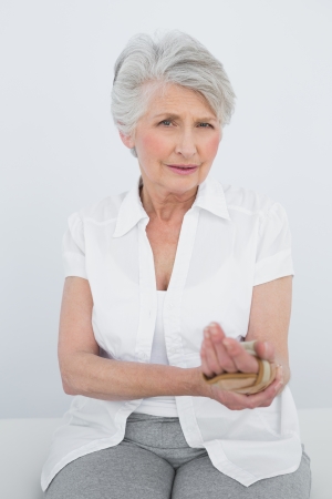 Portrait of a senior woman with hand in wrist brace sitting in the medical officeの写真素材