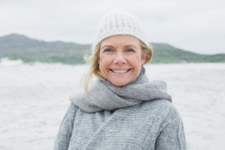 Portrait of a smiling casual senior woman relaxing at the beachの写真素材