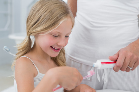 Close-up of mother with daughter brushing teeth in the bathroomの写真素材