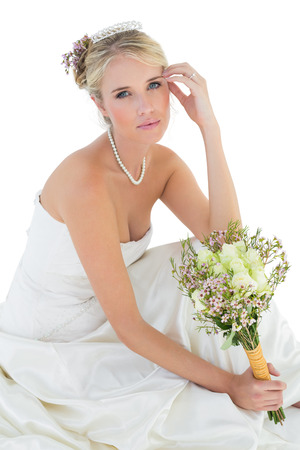 Portrait of sensuous bride holding rose bouquet over white backgroundの写真素材