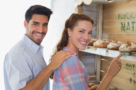 Side view of a young couple at the bakery storeの写真素材