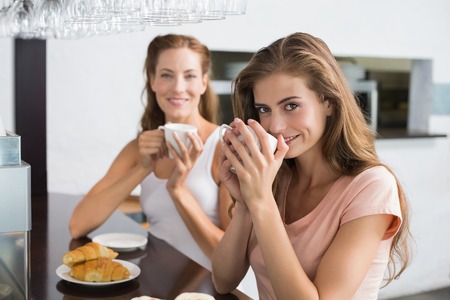 Portrait of two female friends having coffee at the coffee shopの写真素材