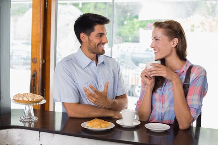 Portrait of a smiling young couple with coffee and croissant at the coffee shopの写真素材