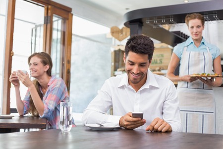 Smiling young people sitting in the coffee shopの写真素材