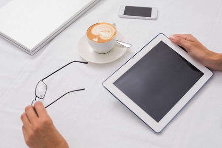 Close-up of digital tablet and coffee on table in the coffee shop