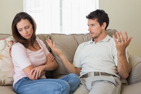 Unhappy couple having an argument in living room at homeの写真素材