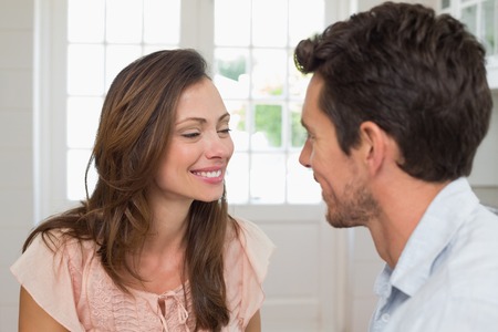 Close-up of a loving young couple looking at each other at homeの写真素材