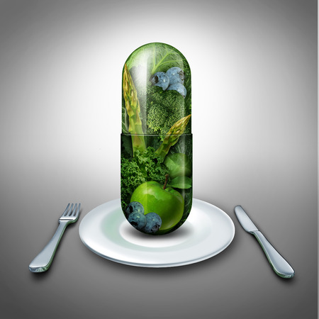 Food supplement concept as a giant pill or medicine capsule with fresh fruit and vegetables inside on a table place setting