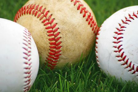 Baseballs in the grass on a baseball fieldの写真素材