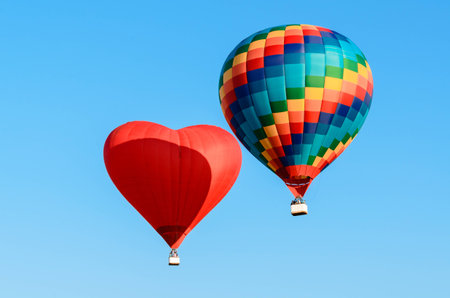 Two colored hot air balloon flying in the blue skyの写真素材