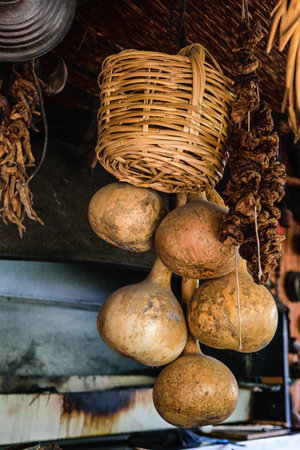 Wicker basket and dry gourd hanging in the kitchenの写真素材