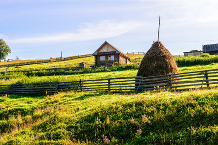 Summer rural landscape with house and haystacks.の写真素材