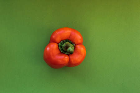 Red pepper on a green background, top view