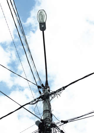 Lamppost with wires against a blue cloudy sky