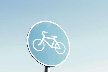 Bike lane sign against blue sky