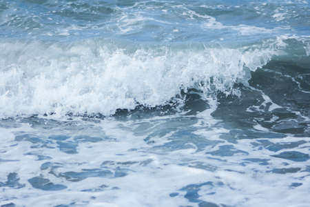 Sea wave crest with splashes and foam