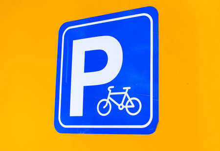 Bicycle parking sign on orange wallの写真素材