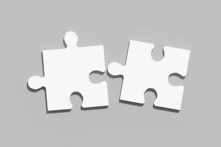 Two white puzzles on a gray background, the concept of joining or separating somethingの写真素材