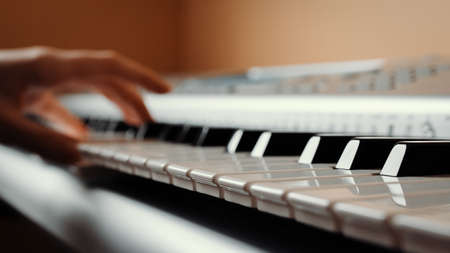 Synthesizer keys with selective focus and hand in the background, synth playingの写真素材