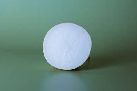 Half cut daikon on a green background, round vegetable, minimalismの写真素材