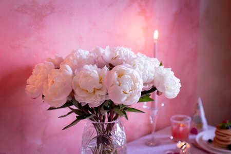 Blossoming white peonies in a vase, flowers for a festive table decoration, selective focusの写真素材