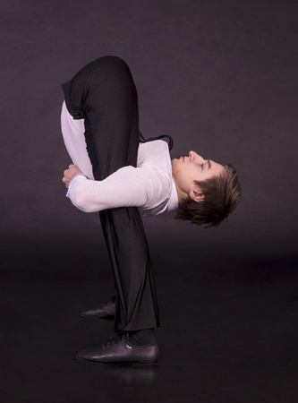 Extraordinary gymnast on a black background. The man with no bones. Studio photography of circus performers ..の写真素材