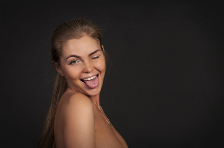 Emotional girl with makeup and hairstyle on a dark background. Emotions when posing. Studio shot on dark background.の写真素材