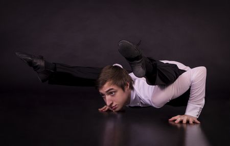 Extraordinary gymnast on a black background. The man with no bones. Studio photography of circus performers.の写真素材