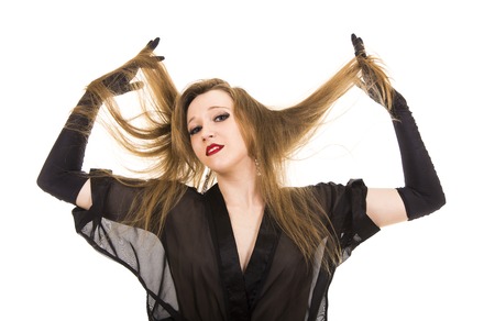 Beautiful young girl in black tunic and black gloves.Posing in Studio on white background isolated image.の写真素材