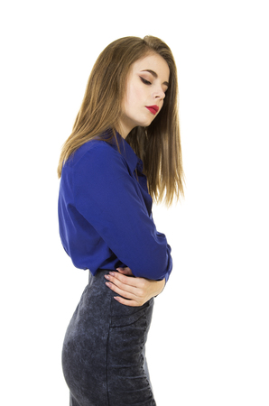 Beautiful, young girl with long hair and makeup, blue shirt and dark skirt.Posing in Studio on white background isolated images.の写真素材