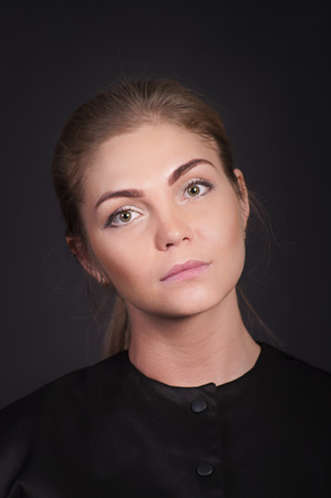 Emotional brunette, with long hair, posing in the Studio. Isolated images on a dark background.の写真素材
