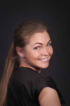 Emotional brunette, with long hair, posing in the Studio. Isolated images on a dark background.の写真素材