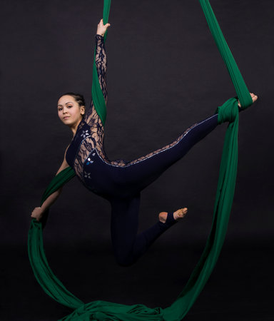 A girl gymnast performs an acrobatic element on the silkの写真素材