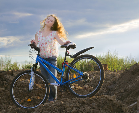 The girl with beautiful hair on a bicycle at sunsetの写真素材