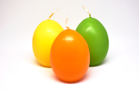 Easter candle in egg form on a white backgroundの写真素材