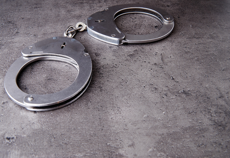 German police handcuff on rough grey background with copy space.の写真素材