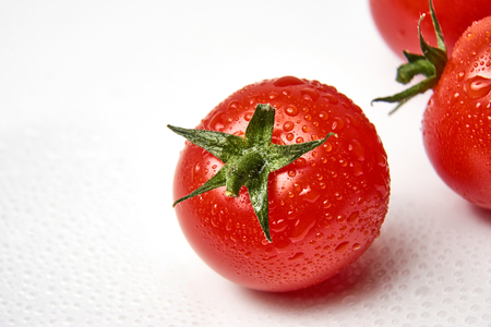 Fresh cherry tomato on white background with waterdropsの写真素材