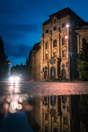 Building in the night with the reflection of a puddle. Traffic lights directly into the camera. Court in Bayreuth, Bavaria, Germany.の写真素材