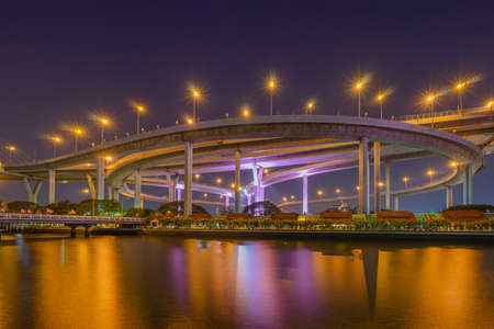 Night scenic of light up on the highway bridge across the riverの写真素材