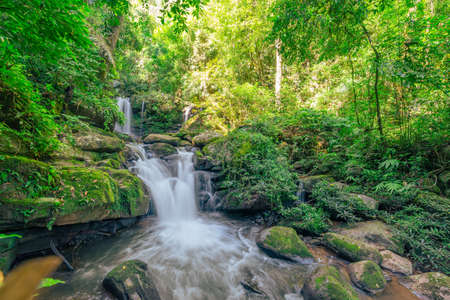 Beautiful waterfall scenic flow from the top into the bottom in the green forest. (Sapun Waterfall in Nan, Northern of Thailand.)の写真素材