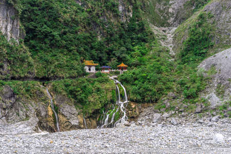 Beautiful scenic of the shrine on the cilff with waterfall down to the river. (Changchun, Shakadang, Taroko, Hualien, Taiwan)の写真素材