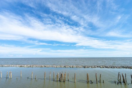 Beautiful natural scenic of the sea with the seperated line with the rock, pole, line of the sea and the sky in background.(Ao Thai Bay in Thailand)の写真素材