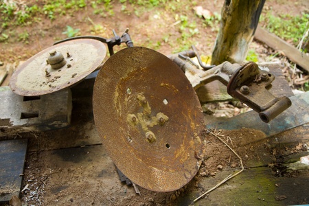 Old disc harrow behind small tractor turning the soil for spring gardenの写真素材