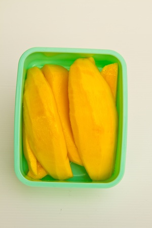 The fresh fruit  mango peel in  box white backgroundの写真素材