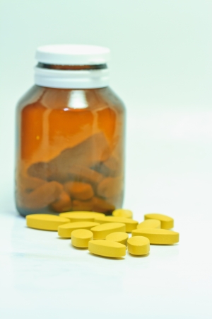 Pills pouring out of the brown bottleの写真素材