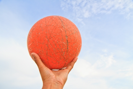 Image of a old basketball on hand and sky backgroundの写真素材