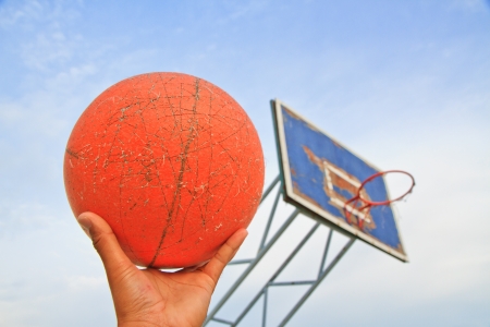 Image of a old basketball on hand and sky backgroundの写真素材
